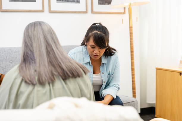 istock Female client looks down while sharing story with unrecognizable therapist 2174235329