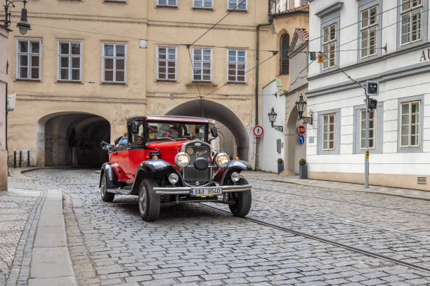 PRAGUE, CZECH REPUBLIC - MAY 6, 2023: Driving a vintage car through the Mala Strana district in the historic centre of town.