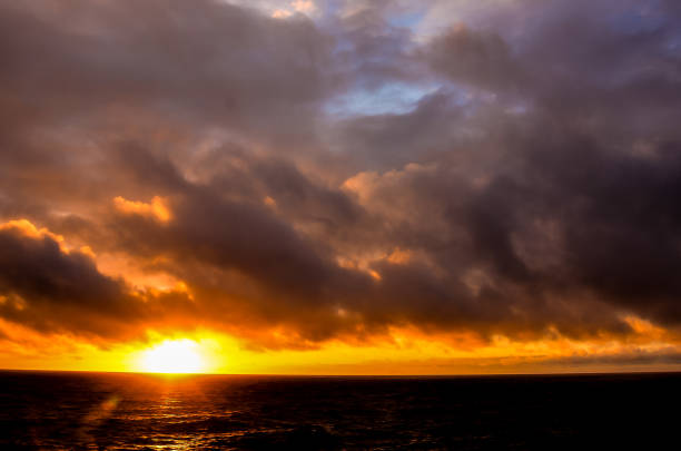 At sunset, the multicolored clouds in the sky above the Baltic Sea in Mielno, Poland, create a unique coastal landscape.