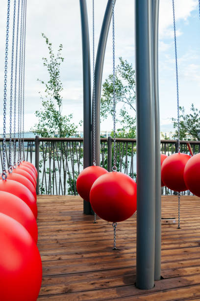 istock walking area on embankment in park. red spherical swing on chains. 2174237745