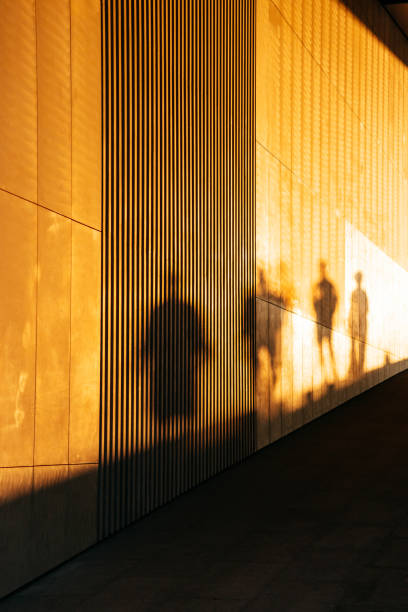 istock shadow of a man on wall during sunset. group of human shadows against a stone wall. 2174238067