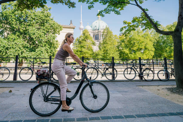 istock Woman riding bicycle with Berlin cathedral in background Germany 2174245373