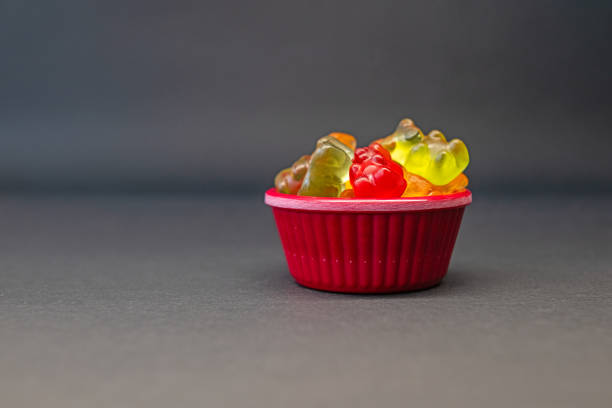 istock Colourful and small gel sweets in a red bowl. Grey ground and background. 2174249624