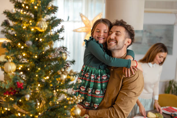 istock Father and daughter share a peaceful Christmas moment by the tree 2174250761