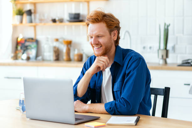 istock Smiling Man Working on Laptop at Home 2174254676