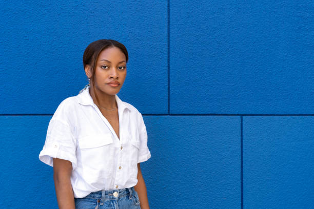 istock Young woman posing with neutral expression against blue wall in bilbao 2174258970