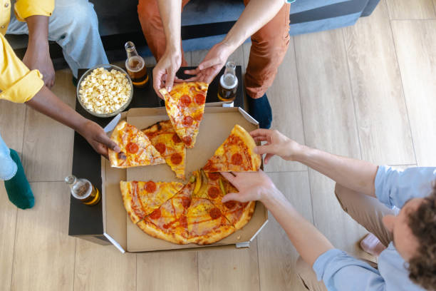 istock Friends sharing pizza and popcorn during casual gathering 2174262427