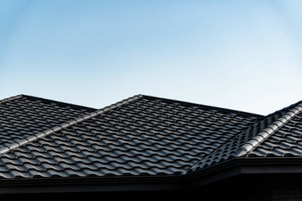 istock The dark tiled roof features a unique pattern and slopes elegantly, contrasting beautifully with the bright blue sky above a suburban home during daylight hours 2174262755