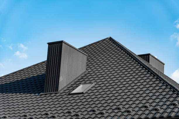 istock The rooftop features a sleek black tile design, highlighted by dual chimneys and a skylight, all set against a vibrant blue sky on a sunny day 2174262764