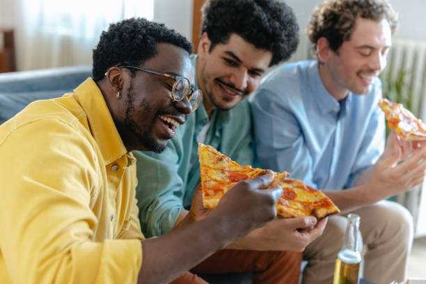 istock Friends enjoying pizza and drinks at home gathering 2174263540