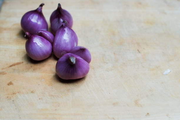 A shallots peeled on wooden cutting board, clean before cooking. It is rich in nutrients such as flavonoids, glycosides and lucokinin and can cook a variety of foods.
