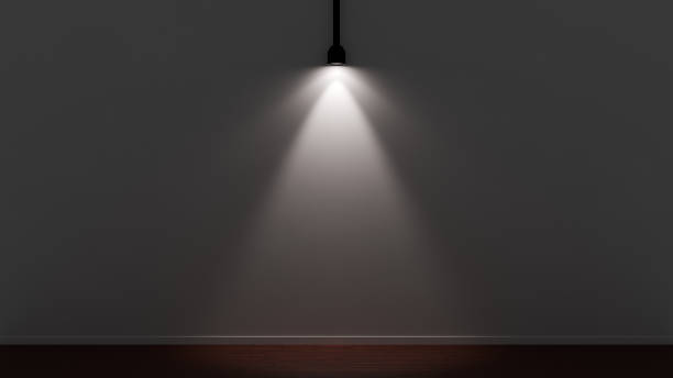 istock A spotlight dramatically illuminate a gray wall in a dark studio with a wooden floor 2174271433