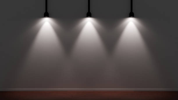 istock Three spotlights dramatically illuminate a gray wall in a dark studio with a wooden floor 2174271441