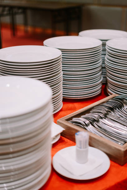 istock A stack of clean plates and spoons neatly arranged on a buffet table 2174271942