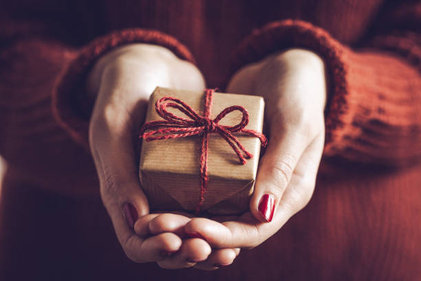 istock Hands holding little gift with red bow. Close up. 2174277725