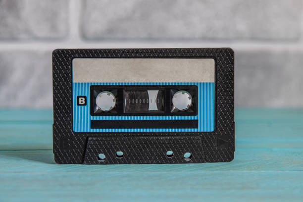 istock A black, slightly dusty audiotape stands on a blue wooden background 2174278305