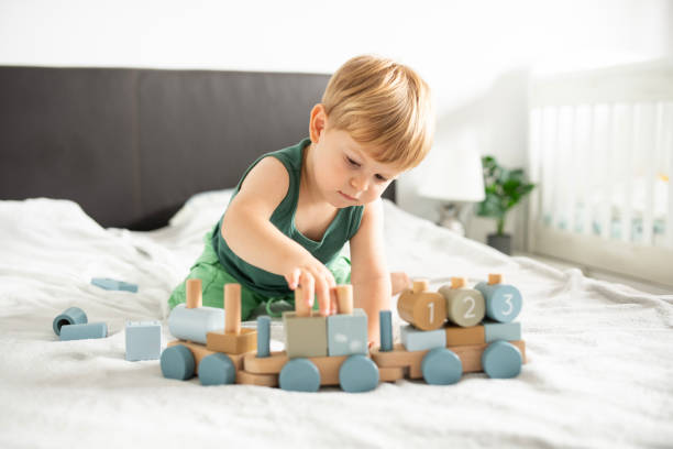 istock Cute little boy is playing with a toy train at home. 2174278659