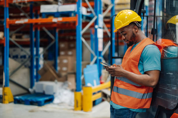 istock African american male warehouse worker using smartphone during break time. 2174278989