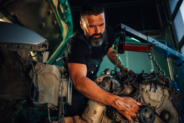 istock Mechanic focusing on car engine repair with tools in garage 2174279026