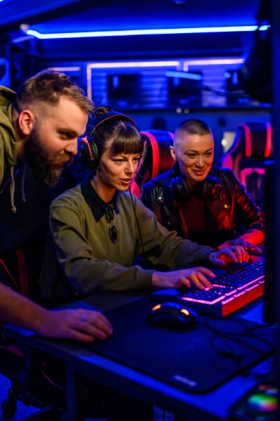 istock Gamer girl with headset playing video game while her friends helping. 2174279081
