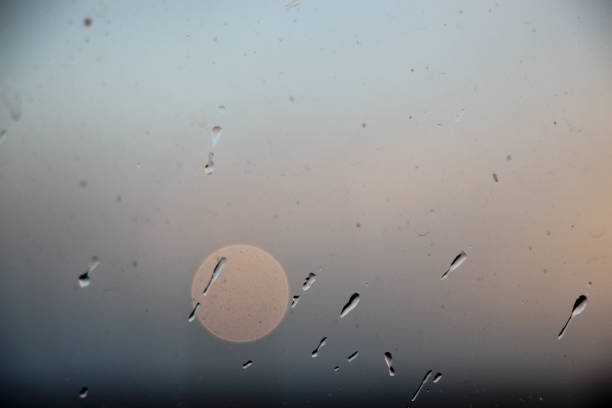 Drops of rain on window with abstract lights