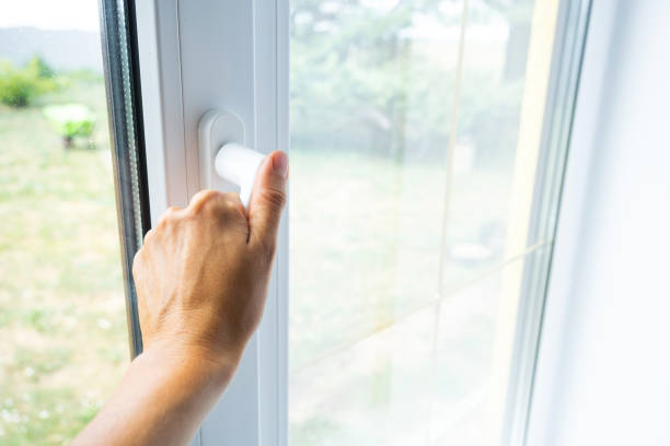 istock The hand holds the handle of a plastic double-glazed window, closing and opening the window with a rotary mechanism, the position of the handle for ventilation, micro-ventilation 2174287624