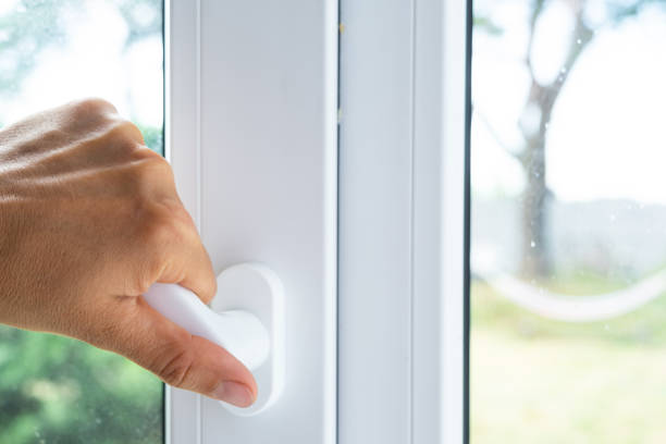 istock The hand holds the handle of a plastic double-glazed window, closing and opening the window with a rotary mechanism, the position of the handle for ventilation, micro-ventilation 2174287629