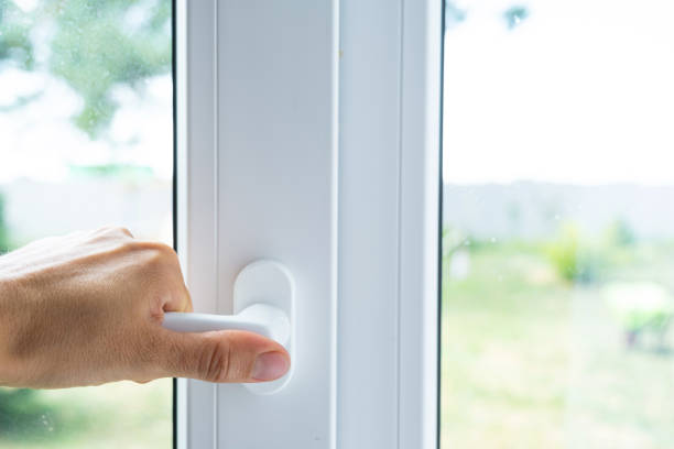 istock The hand holds the handle of a plastic double-glazed window, closing and opening the window with a rotary mechanism, the position of the handle for ventilation, micro-ventilation 2174287634