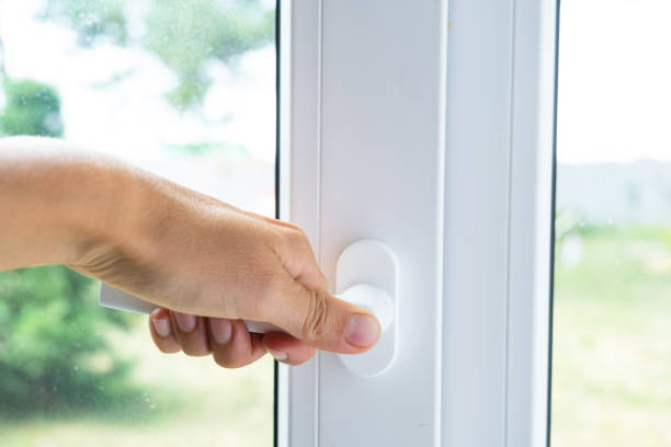 istock The hand holds the handle of a plastic double-glazed window, closing and opening the window with a rotary mechanism, the position of the handle for ventilation, micro-ventilation 2174287641