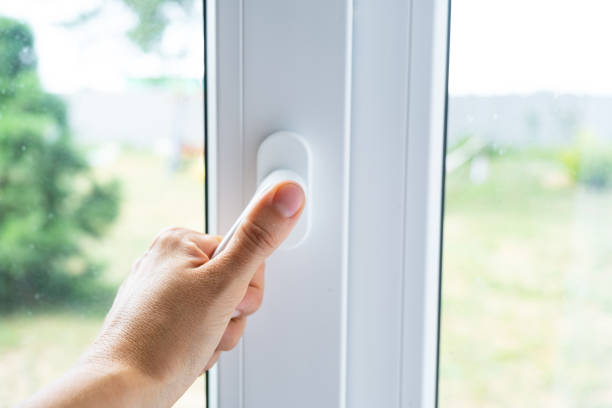istock The hand holds the handle of a plastic double-glazed window, closing and opening the window with a rotary mechanism, the position of the handle for ventilation, micro-ventilation 2174287650
