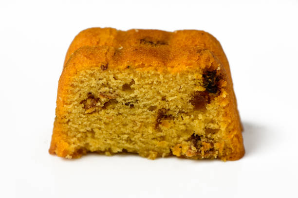 A high angle close up shot of a date cake with a slice missing and some medjool  dates.