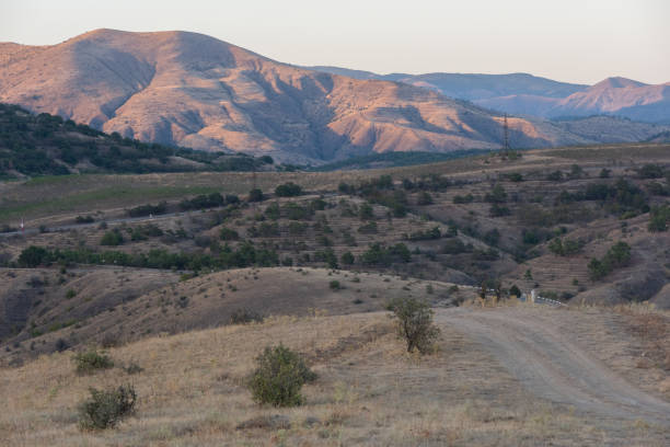 Volcanic mountains in Crimea, dirt roads and sunset light landscape