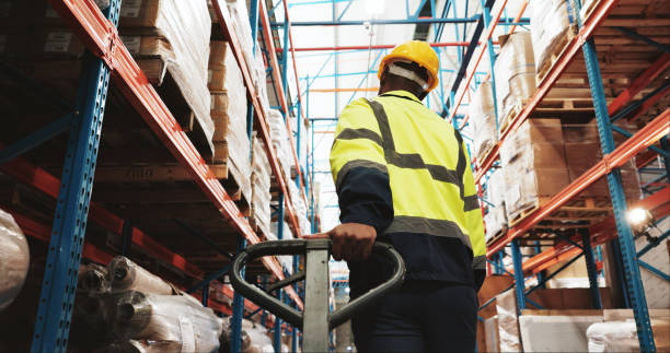 istock Warehouse, man and worker pull pallet truck for supply chain, restock inventory or moving storage freight. Factory, engineer and trolley for cargo, distribution logistics or back in shipping industry 2174296619