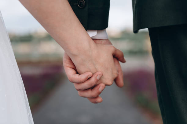 istock bride and groom hold hands together 2174298235