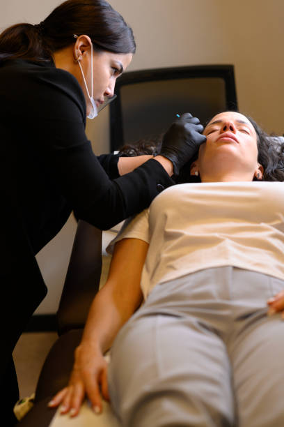 istock Beautician applying permanent eyebrow makeup on woman 2174299414