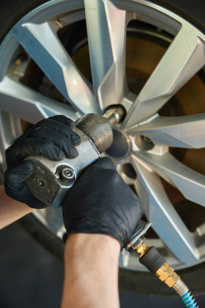 istock Mechanic unscrews a nut on a wheel rim 2174299638