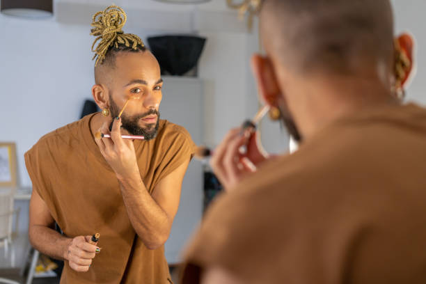 istock Black Brazilian gay applying make up eyeshadow looking mirror 2174300207