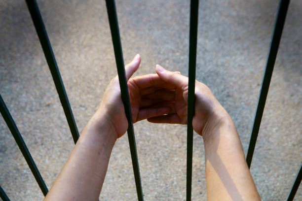 istock Hands Reaching Through Metal Bars in Urban Setting 2174306056