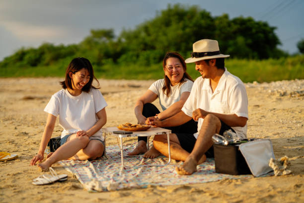 istock Three mid adult friends watching the sunset on a beach 2174309516