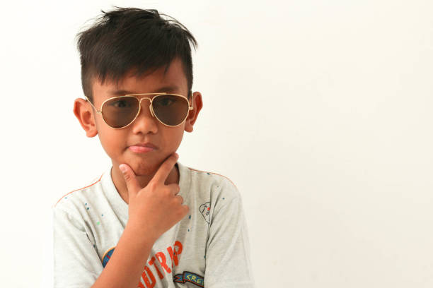 Handsome boy wearing glasses. fingers touch chin. Isolated on white background. Copy space.