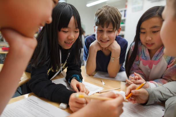 istock Group of multiracial elementary school students talk and enjoy studying together in a classroom with Asian Chinese girl classmate 2174314544