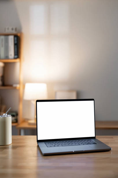 istock Mockup blank white screen laptop computer on wooden table in home office room. 2174315859