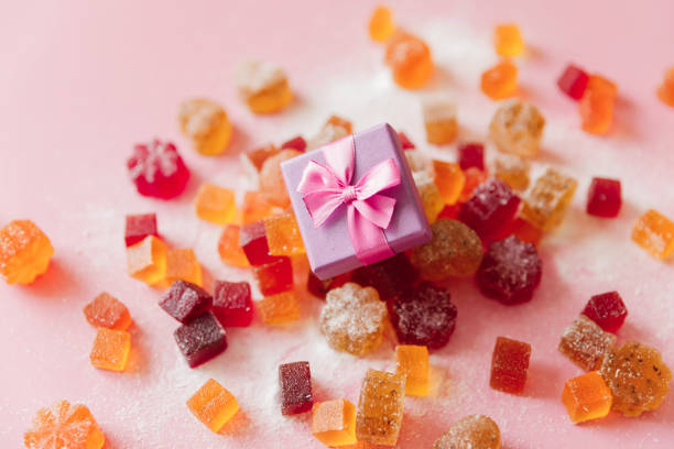 Sweet yummy jelly on pink background with gift box.