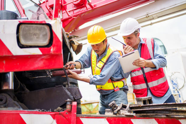 istock Team of workers at construction site with heavy machines. 2174325181