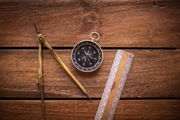 Vintage ruler, drawing and navigational Compass on a rustic wooden board