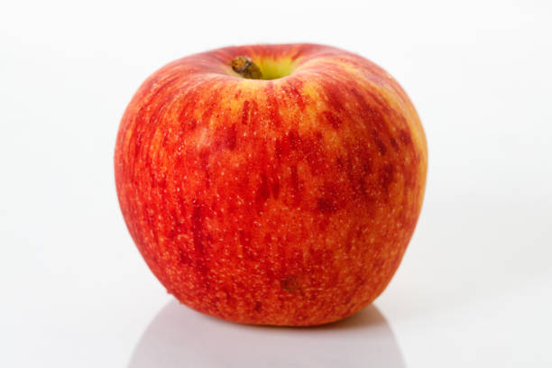 Closeup of ripe organic red apple on white table background. Selective focus.