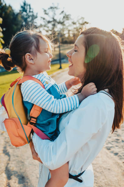 istock Mother kissing daughter in park 2174328050