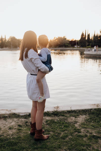istock Mother and daughter standing near water 2174328201