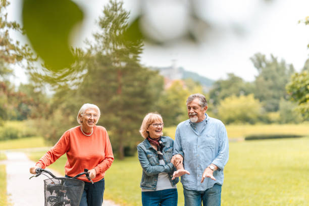 istock Senior Friends Enjoying Park Walk with Bicycle 2174331147