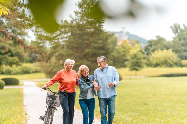 istock Senior Trio Enjoying Leisurely Park Stroll with Bicycle 2174331169